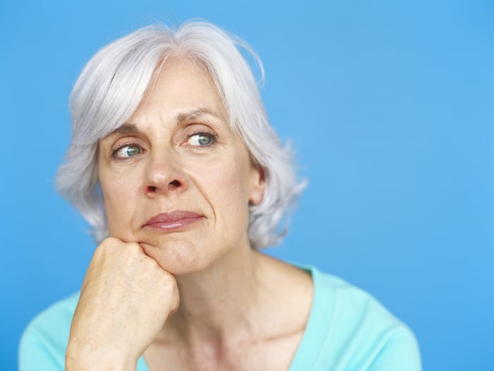 A person is resting their chin on their fist, looking thoughtful.