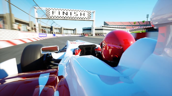Person driving race car across finish line.