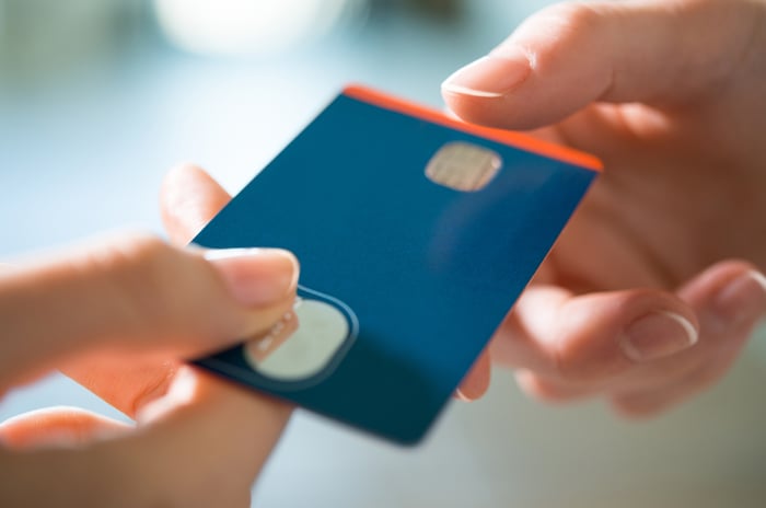 A blue credit card changing hands.