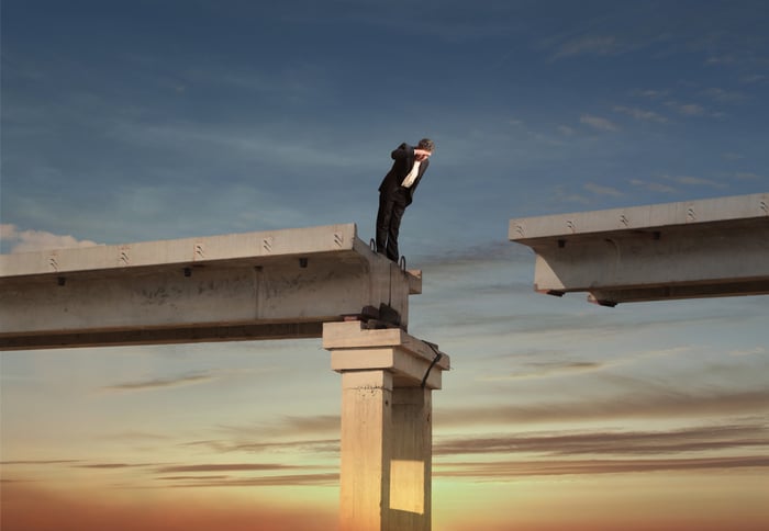 Man looking down from a bridge.