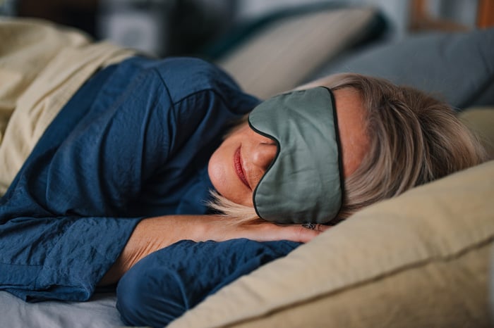 Person in bed with a sleep mask.