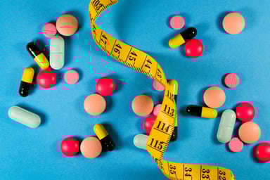 25_12_29 A tape measure with a pile of pills _GettyImages-1348209410-1200x800-5b2df79