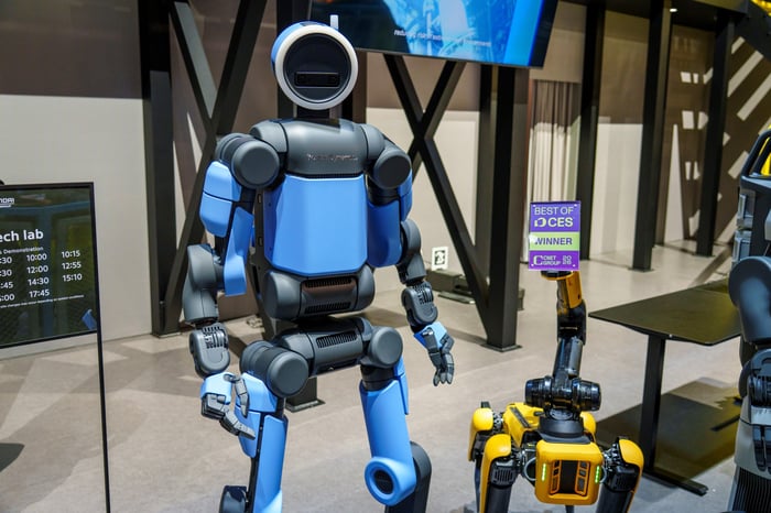 The blue Boston Dynamics Atlas robot with the Spot next