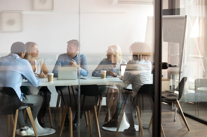 A group of people gathered around a table in an office.