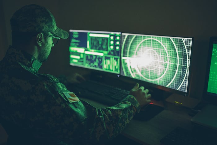 A soldier at a computer with what looks like a radar screen displayed. 