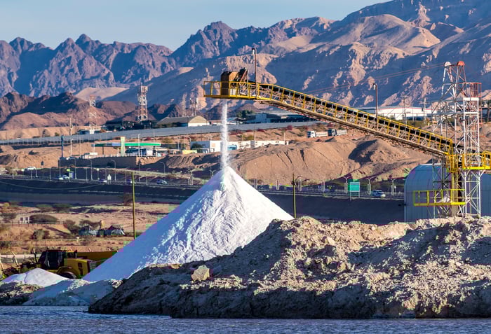 A crane dumps gravel into a big pile.