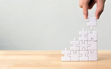 25_03_02 A hand building a puzzle vertically _MF Dload GettyImages-1054149870-1200x750-7d59391