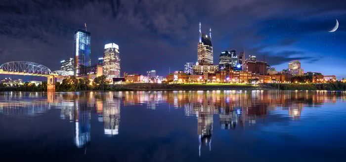 Nightscape of Nashville, Tennessee with buildings reflected in the Cumberland River.