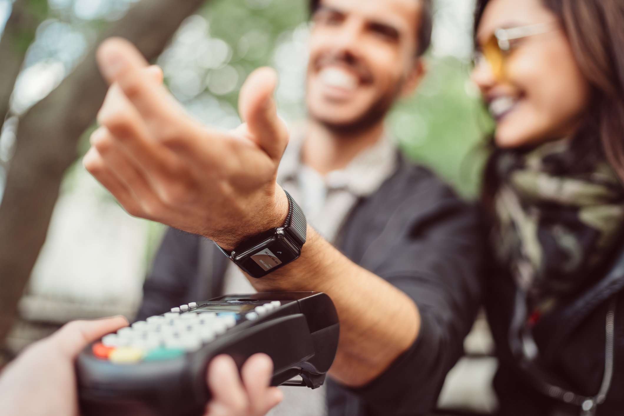 sitting at sidewalk cafe and paying contactless smart watch