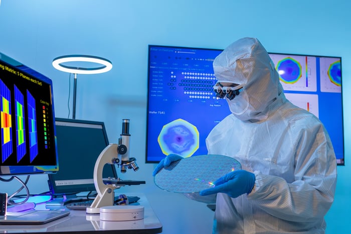 Engineer inspecting memory chip in a factory.