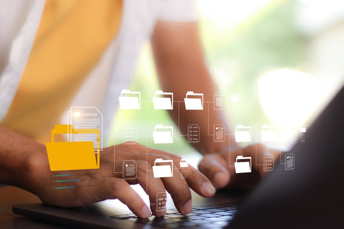 Hands on a keyboard with images of software and folder icons