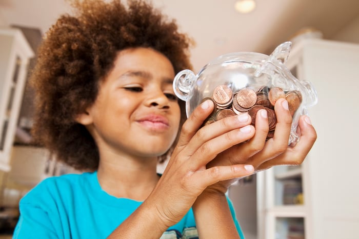 A child collects coins in a piggy bank.