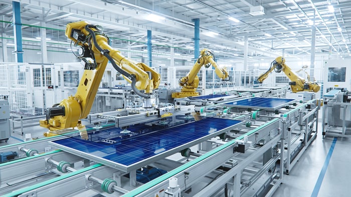 Industrial robot arms at a large manufacturing facility. 