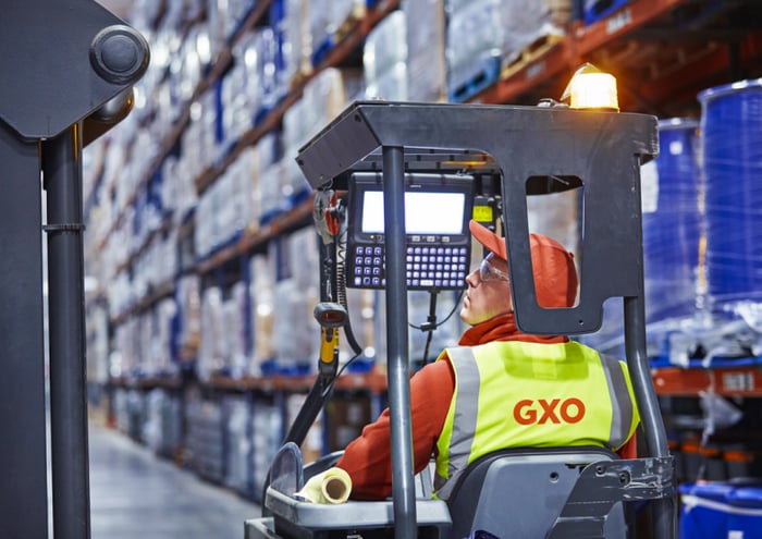 A warehouse worker in a GXO vest.
