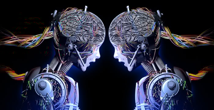 Two robots with wires out of their heads look at each other.