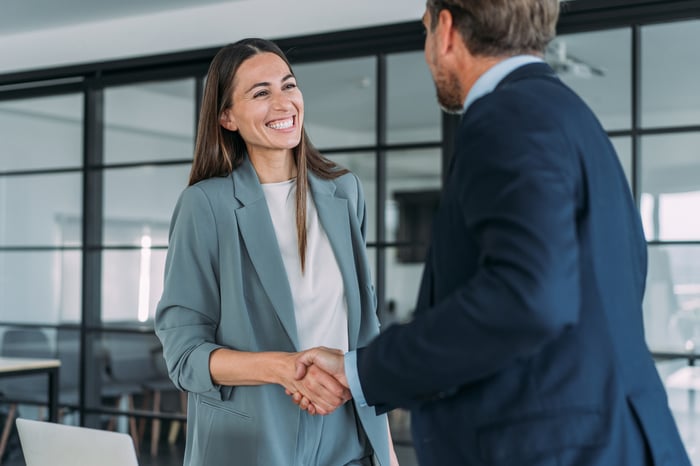 Colleagues shaking hands in an office.
