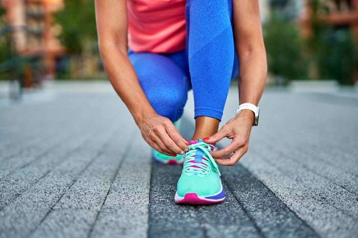 An athlete tying their shoe.