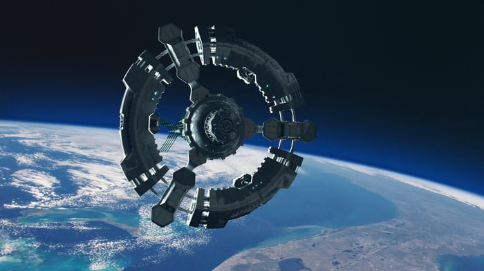 A circular space station in orbit over Earth.