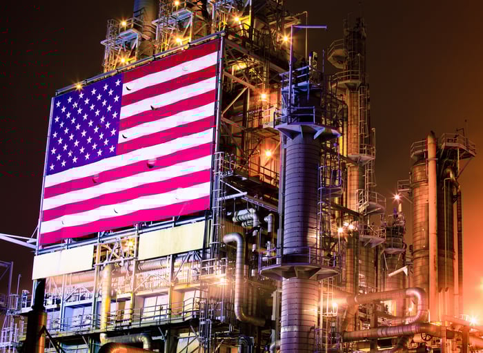 Oil and gas infrastructure with an American flag.