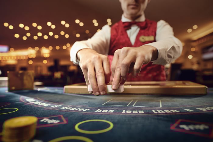 A dealer shuffling cards at a casino.