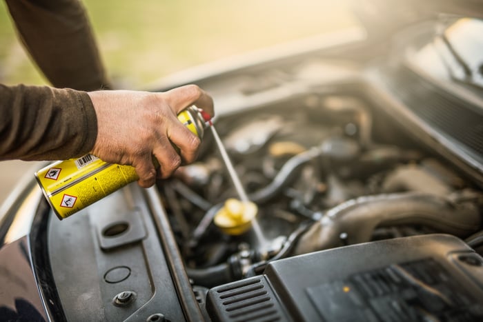 A mechanic spraying an engine.