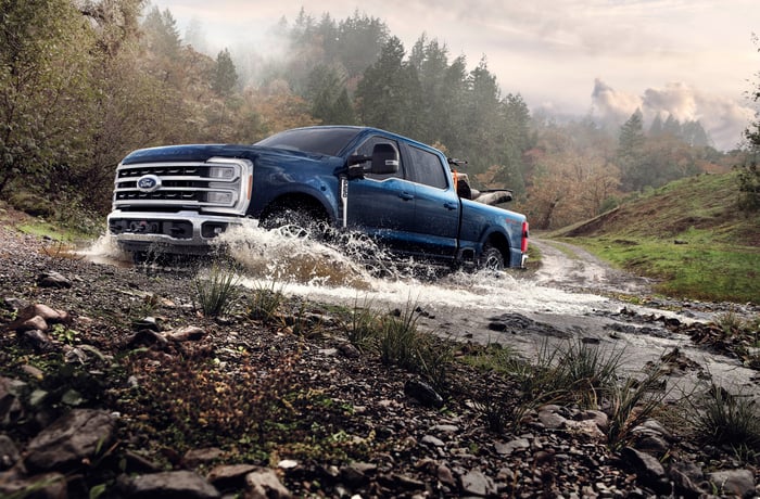 Ford F-Series truck driving through a stream. 