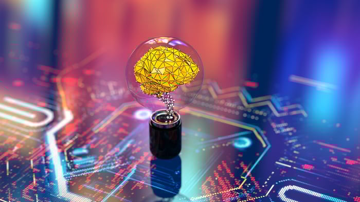A small yellow brain in a bulb on what looks like a circuit board. 