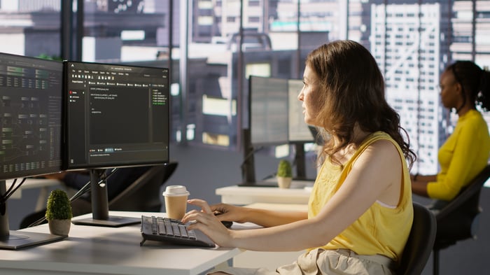 Two women working at computer terminals. 
