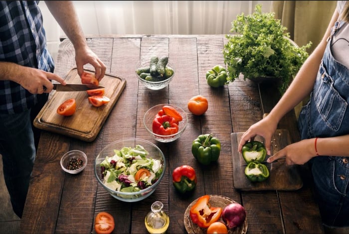 Fresh produce being cut on wooden cutting boards. 