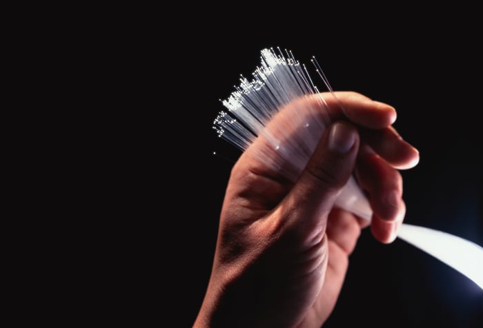 A hand holding a bundle of lighted fiber-optic fibers.