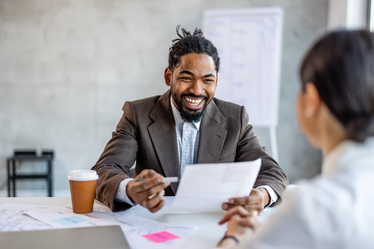 Businessperson laughing while talking to a colleague