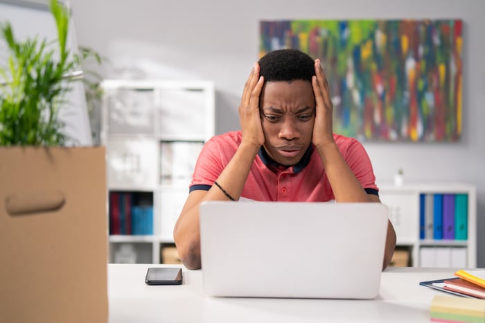 A frustrated investor looking at a computer.