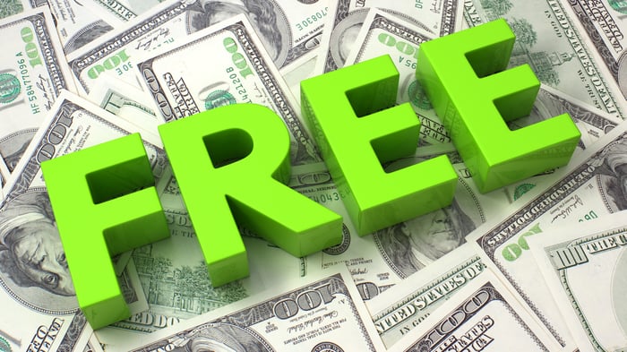 A sign reading FREE on top of a pile of cash.