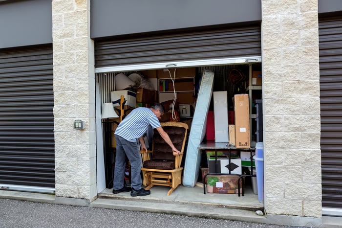 A person is placing items in a storage unit. 