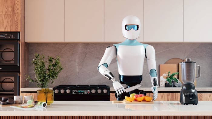 A robot cuts up fruit in a kitchen. 