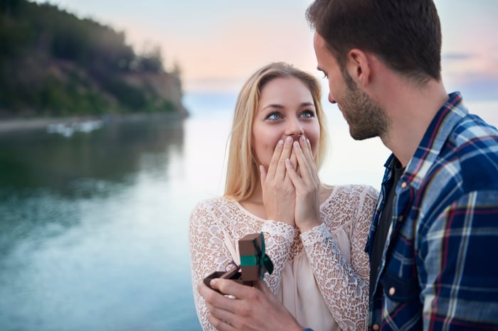A happy couple is celebrating a marriage proposal with a diamond engagement ring. 