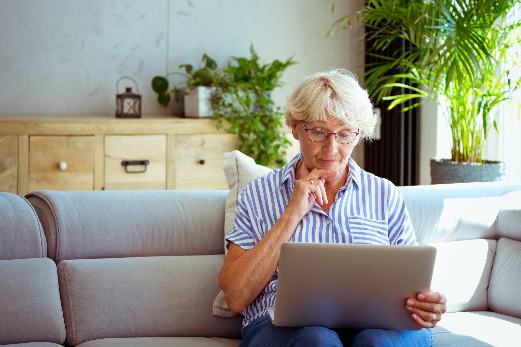 Senior woman holding laptop GettyImages-1278976690