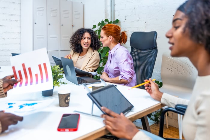 People at a table talking and looking at charts.