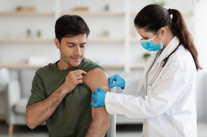A healthcare worker finishes vaccinating a patient.