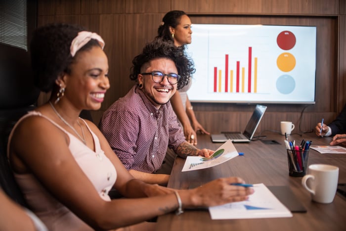 Professionals smiling in a conference room.