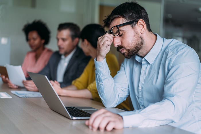 A disappointed person sitting in front of a laptop.