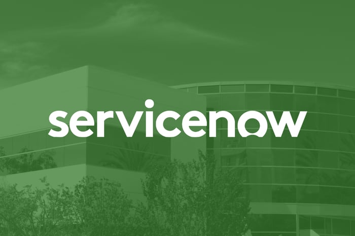 The word "Servicenow" is overlaid on top of an image of an office building.