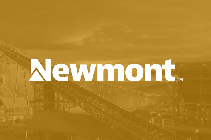 Newmont company logo in white over gold-colored view of mine. 