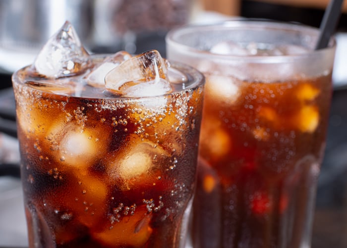 Two glasses with cola on ice.