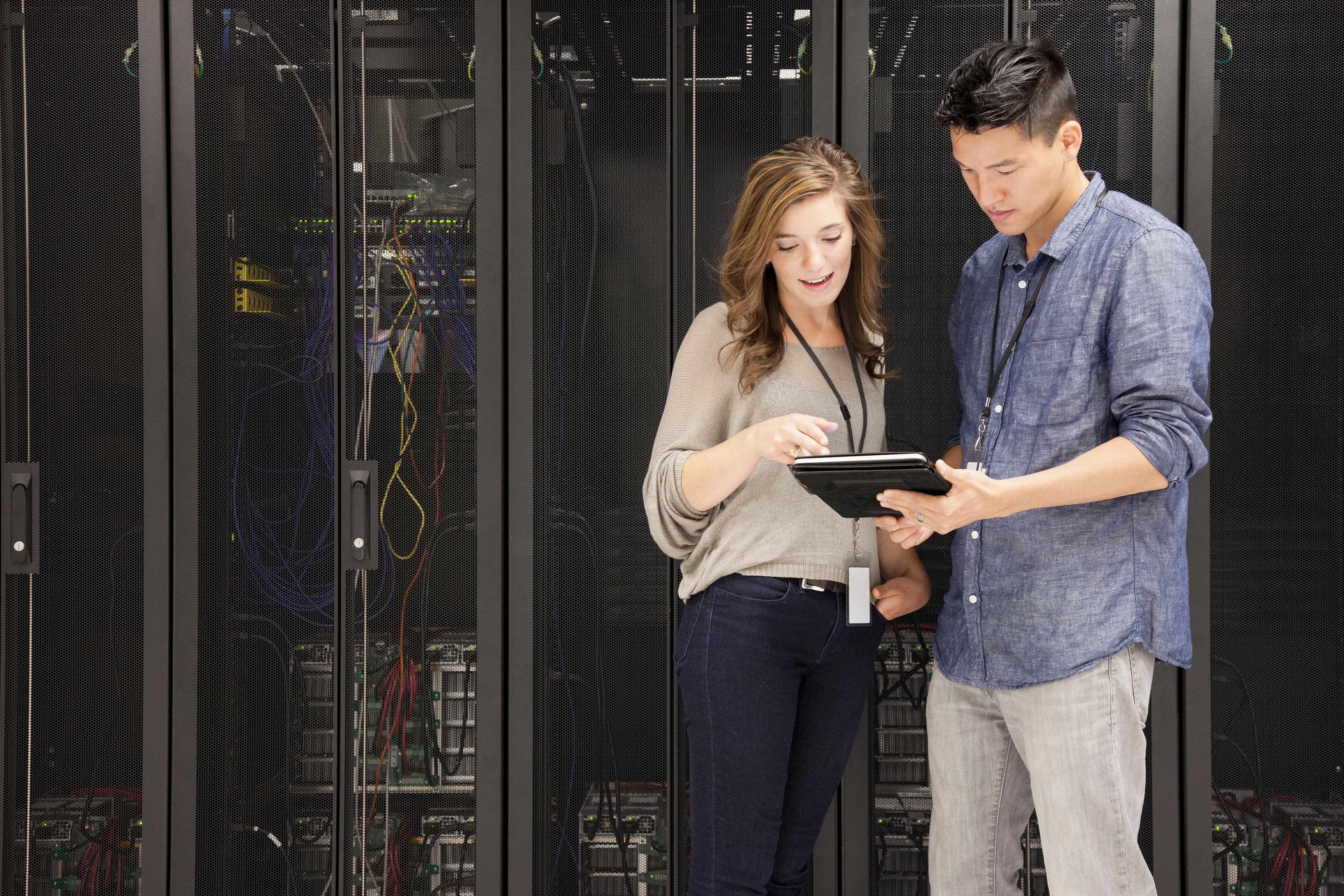 People viewing a mobile device in front of stacks of supercomputers
