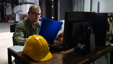 construction worker with hat off looking at tablet