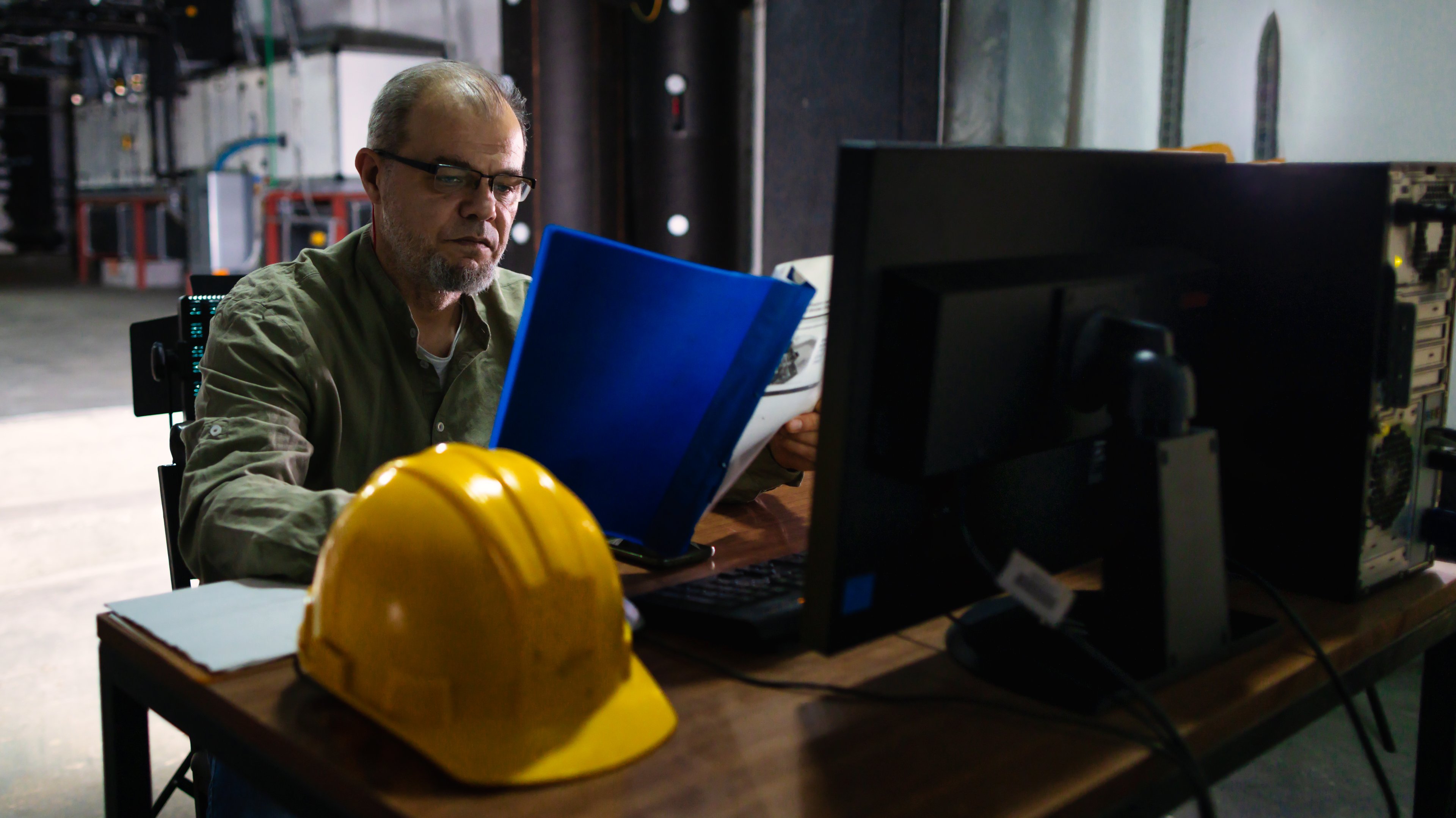 construction worker with hat off looking at tablet