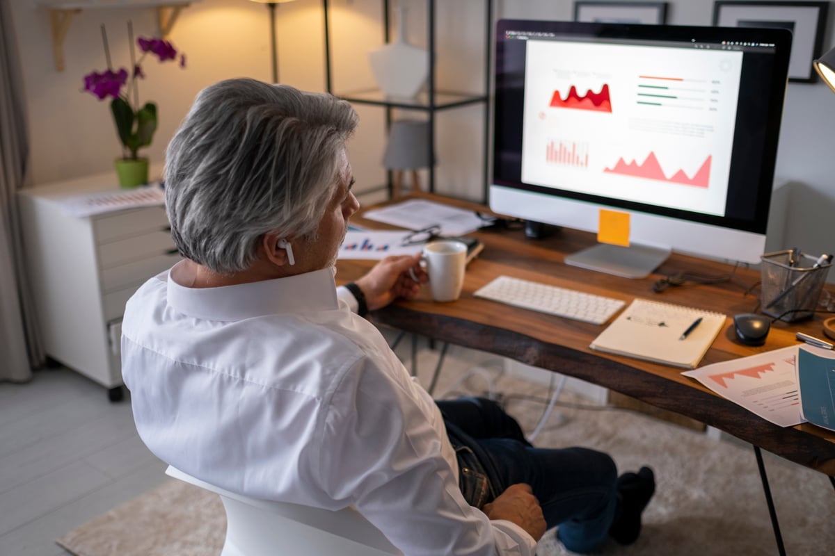 investor examines financial charts on desktop computer.