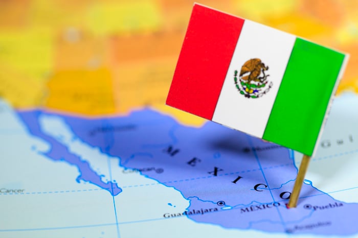 A flag of Mexico on a map of the country.