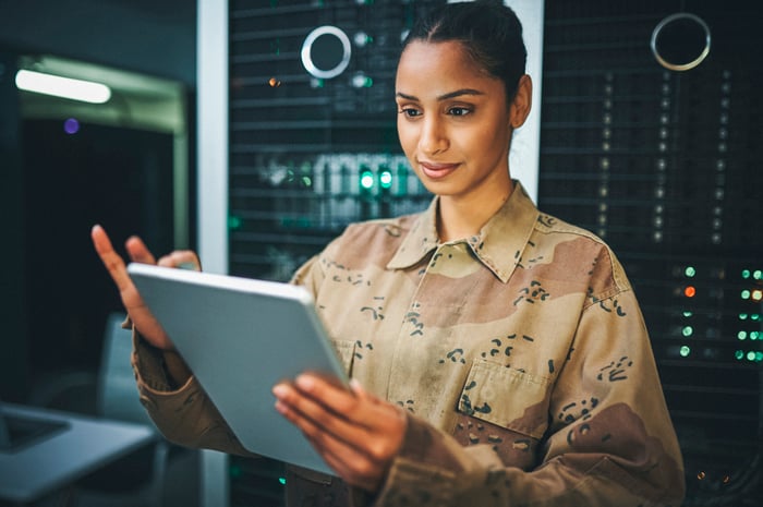 A soldier analyzes data inside a data center.